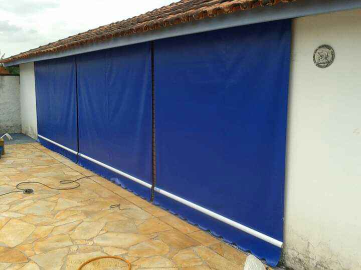Toldo cortina azul sem visor em área externa residencial