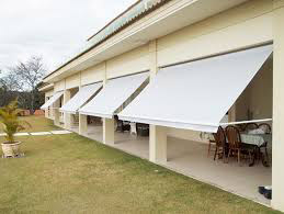 Toldo retrátil branco instalado em área externa residencial