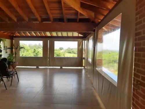 Toldo cortina bege em área gourmet com telhado de madeira